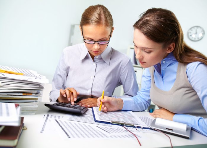 Concentrated business women reviewing accounting report