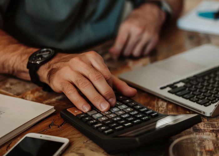 Person using a financial calculator, planning their savings and investments